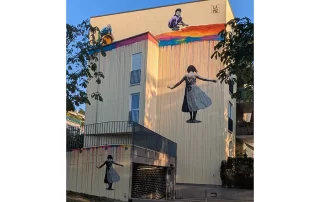 Street Art Mural "Toxic Colours are Beautiful" by LAPIZ, dancing girl in colourful rain, children working in toxic waste
